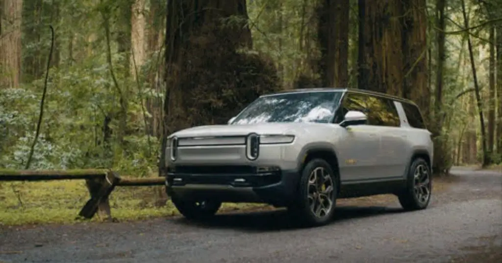 white Rivian r1s in the forest