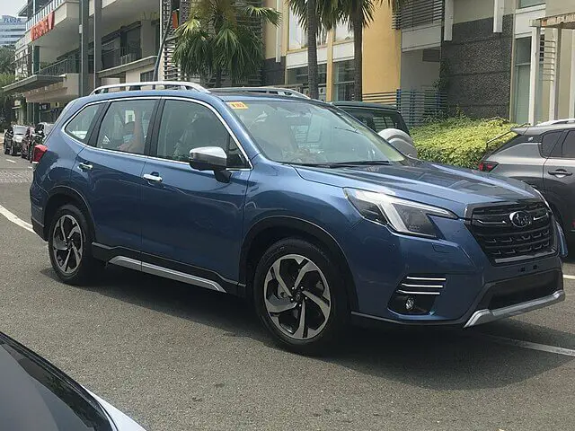 A vibrant blue 2024 Subaru Forester parked on the street, highlighting its modern design and robust features