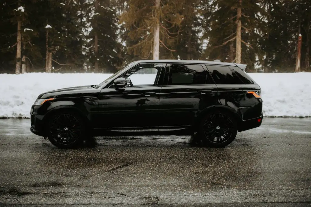 black land rover range rover sport in the woods