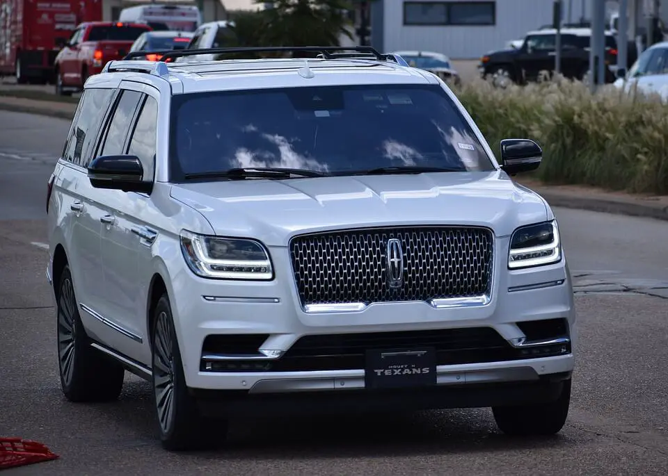 White Lincoln Navigator driving in the city