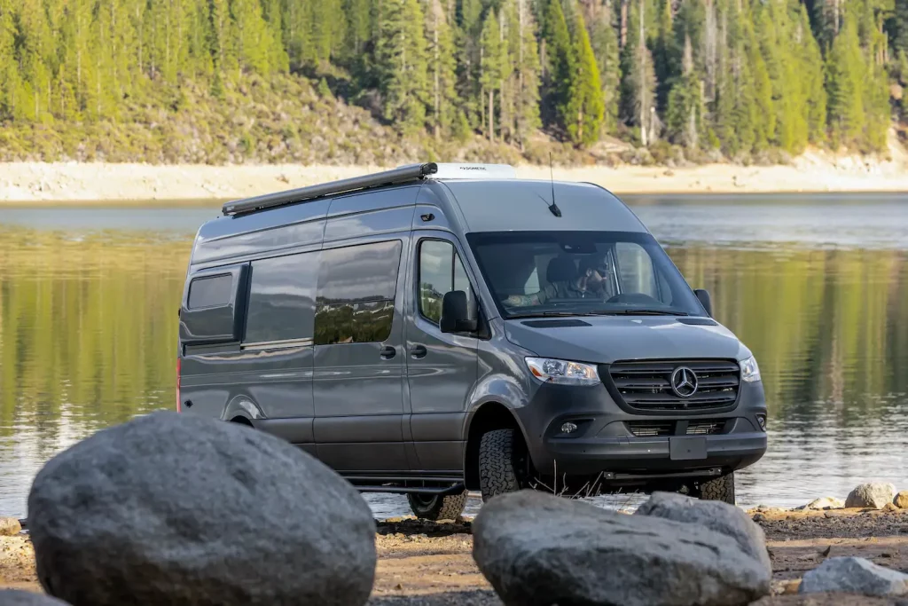 grey Mercedes Sprinter Camper Van parked by the lake in the forest