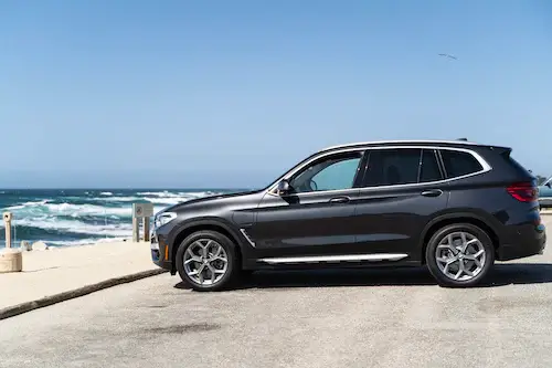 BMW X5 parked at the beach by the ocean